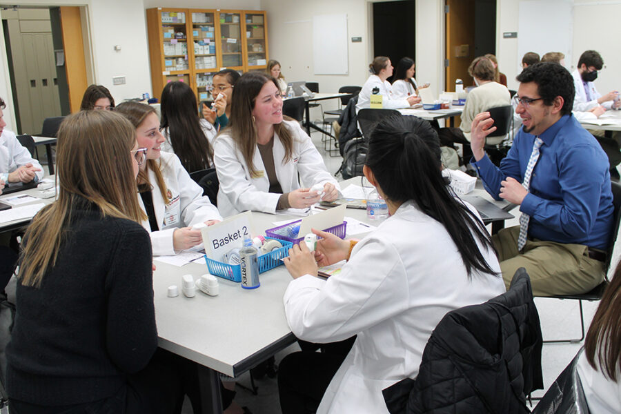Associate Professor Ed Portillo (PharmD '14) (right) teaches about asthma devices in the Pharmacotherapy Lab.