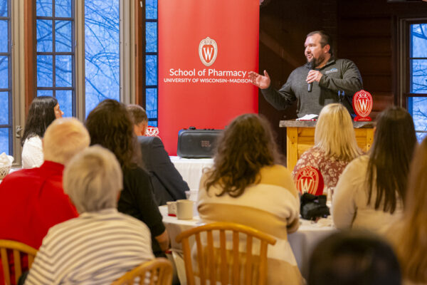 An alum speaking in front of a group