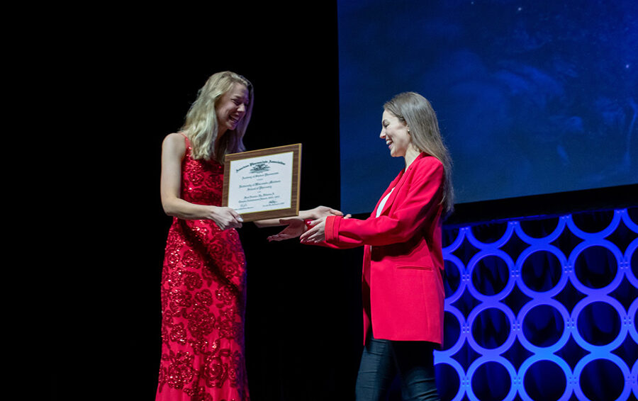 PharmD student Lauren Glaza (right), 2023–24 WSPS president, accepts the National First Runner-Up for the Chapter Achievement Award in Division A for 2022–23.