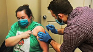 PharmD student Eric Eitel delivering a COVID-19 vaccine