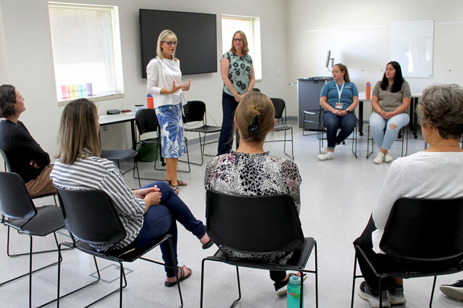 Professor Beth Martin (BS ’90, MS ’03, PhD ’06) (standing, left) leads a meeting with the newly integrated Clinical Pharmacy, Innovation, and Research Division. | Photo by Sally Griffith-Oh