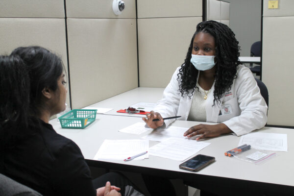 PharmD student Ebunoluwa Olapo counsels a standardized patient about safely participating in religious fasting as part of the School of Pharmacy's Communications Lab.