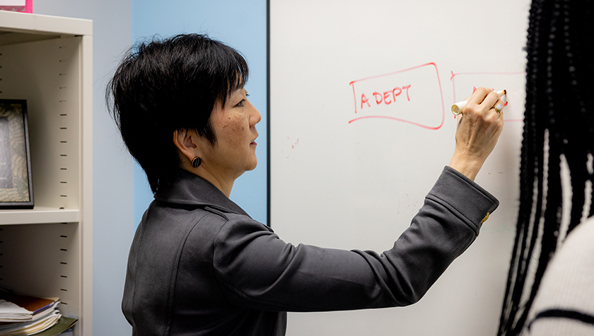 Michelle Chui writes on a chalkboard