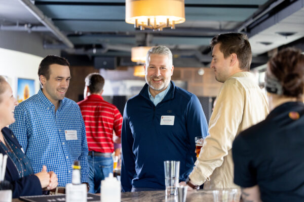 Andrew Wilcox speaks with other alumni