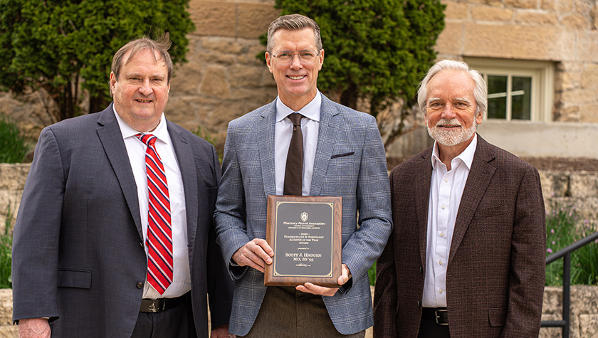 Scott Haugen poses with his award, School of Pharmacy Dean Steve Swanson, and Professor Jeff Johnson