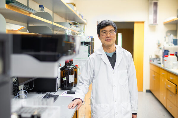 Weiping Tang stands in his lab