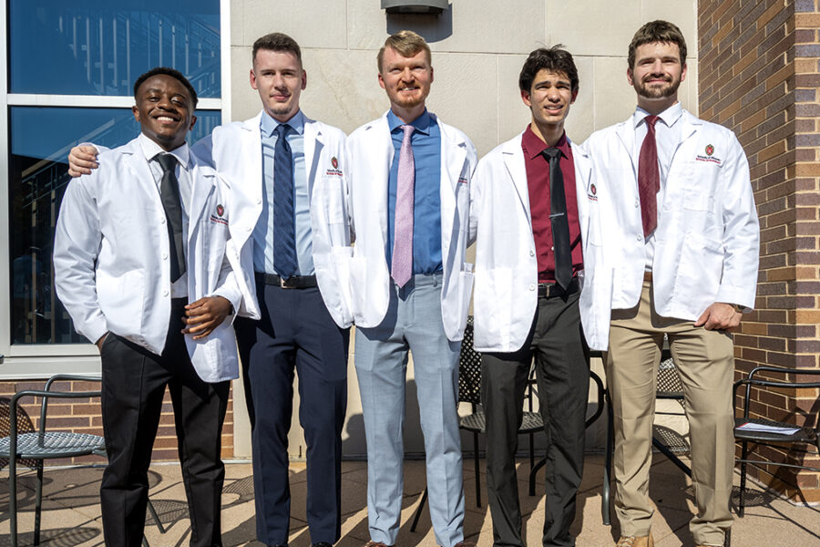 Five male students in the Class of 2029 pose in their white coats