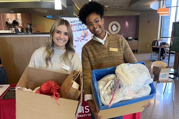 Two PharmD students hold boxes of collected medications