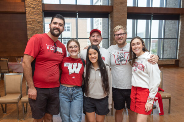 A group of alumni in Badger gear pose for a photo